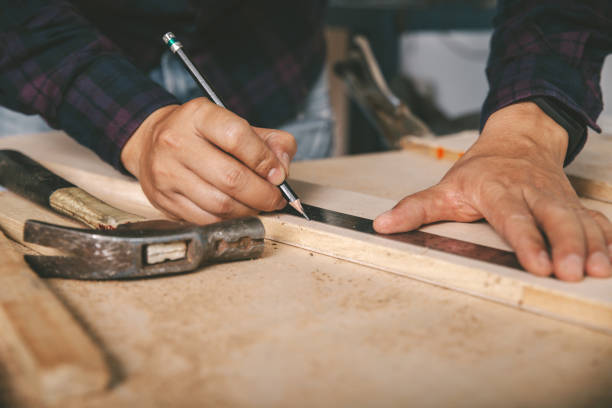 istock carpenter with a pencil and ruler mark on wooden board on table. Construction industry, housework do it yourself. 1220081607
