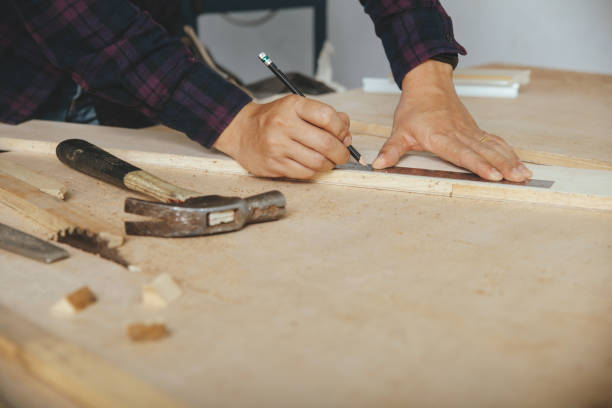 istock carpenter with a pencil and ruler mark on wooden board on table. Construction industry, housework do it yourself. 1220081643