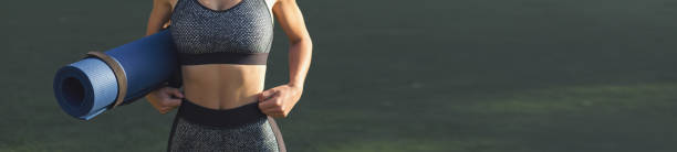 A young slim athletic girl in sportswear with snakeskin prints performs a set of exercises. Fitness and healthy lifestyle. stock photo