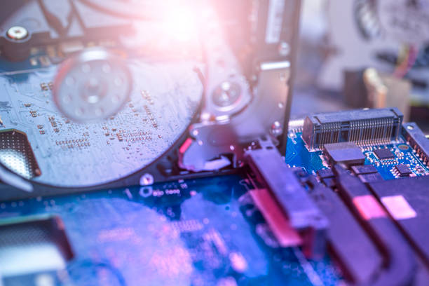 istock The concept of data, hardware, and information technology, the image of inside of hard disk drive on the technician's desk and a computer motherboard, toned, focus in the reflection of the hard drive, 1220081943