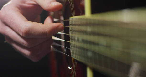 istock Portrait of a guy playing guitar, he is studying new chords. 1220083082