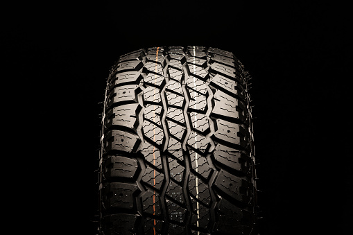 all terrain new tire for off-road and off-road vehicles and crossovers close-up on a black background.