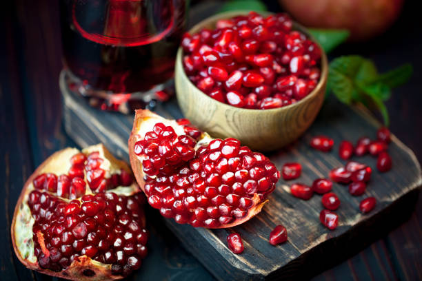 istock Ripe pomegranate fruit on a old black wooden vintage background. Selective focus. 1220087236