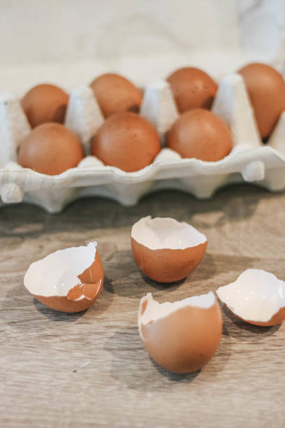istock Close-up view of raw chicken eggs in egg box on wooden background and crashed eggs 1220087318