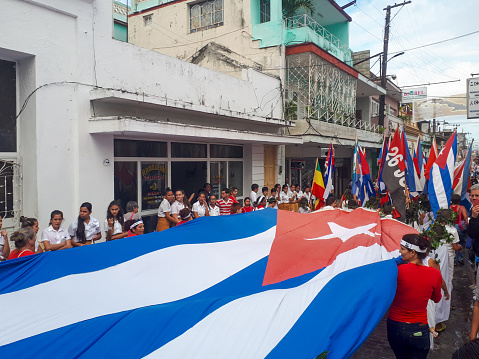 Santa Clara, Cuba-January 28,2020: Cuban pioneers march with a national flag celebrating the life of Jose Marti who was a leader in the independence struggles and is remembered as the 'Cuban National Hero'