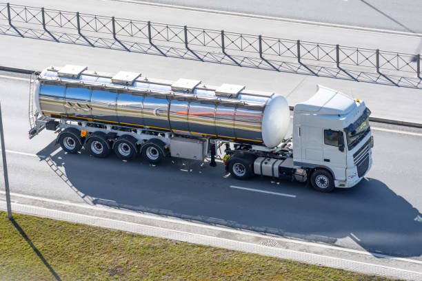 schwere große kraftstoff tanker mit glänzenden metall lahm tank fahren auf der stadtautobahn, seitliche luftansicht. - armored truck stock-fotos und bilder