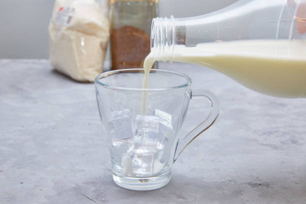 istock Step 6. Dalgona coffee. Step by step cooking. Pour milk into a cup. Add ice as desired. 1220091526