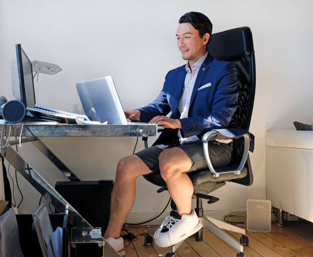 Man wearing a suit for the video call while also wearing sweatpants stock photo