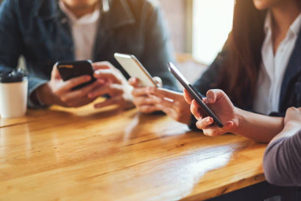 istock Group of people using and looking at mobile phone together 1220093881