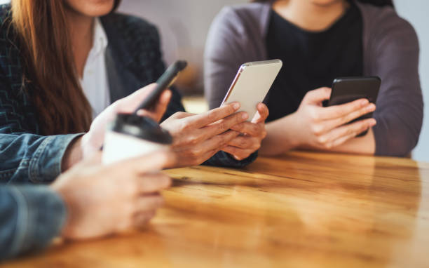 istock Group of people using and looking at mobile phone together 1220093912