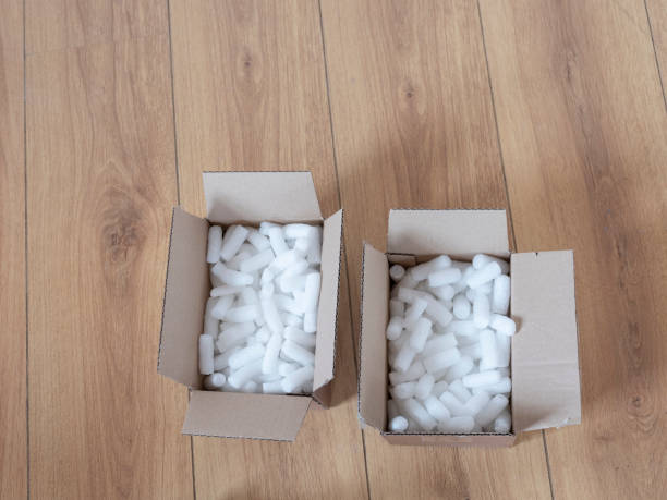 istock Two cardboard boxes with packing foam pellets top view, on wooden floor 1220096993