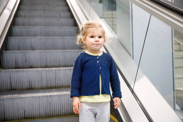 adorável garotinha no aeroporto. adorável criança caminhando para o portão e indo em férias em família de avião. criança feliz positiva. - escalator child shopping mall little girls - fotografias e filmes do acervo