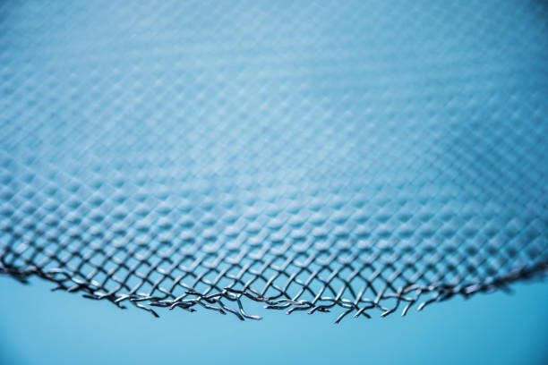 istock Abstract metal mesh fence closeup blue monochrome for banner with empty space for text 1220097665