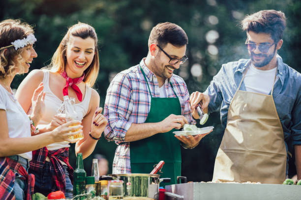istock Group of people standing around grill, chatting, drinking and eating. 1220099484