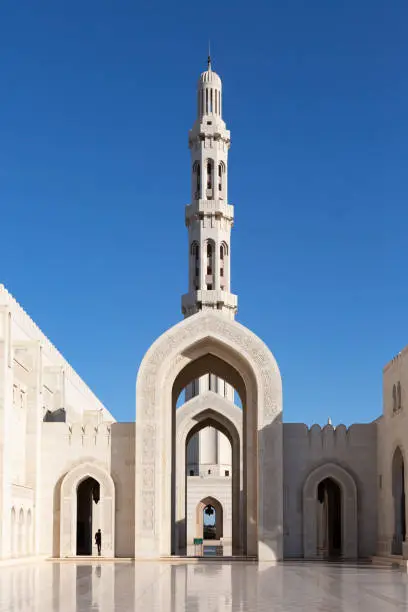 Minaret towering over archways of Sultan Qaboos Grand Mosque in Muscat/Oman