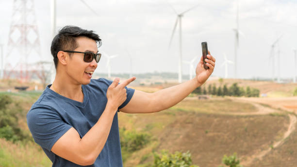 istock Asian young man using a telephone at a mountain. 1220105641