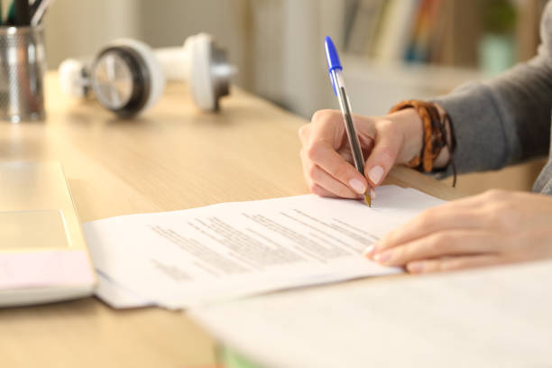 istock Student girl hands signing contract at home 1220106610