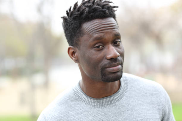 istock Suspicious black man looking camera in a park 1220107831