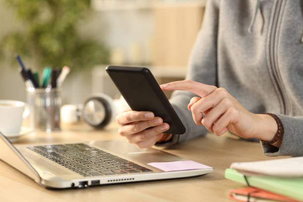 istock Student girl hands checking phone on a desk 1220107913