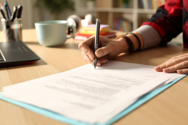 istock Student girl hand signing contract at night 1220107964