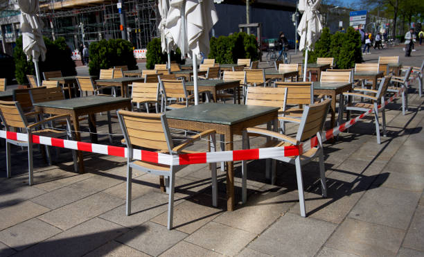 locked seating area during the corona crisis in a restaurant Wolfsburg, Germany- 04/21/2020: stretched security tape at tables to keep social distance to slow down a spread of COVID-19 coronavirus in a store relief map photos stock pictures, royalty-free photos & images