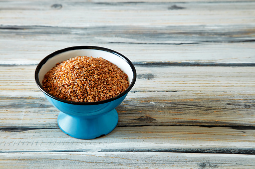 Einkorn, siyez wheat bulgur, wheat in blue enamel bowl