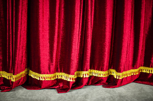 istock Theatrical red velvet curtain on stage 1220111270
