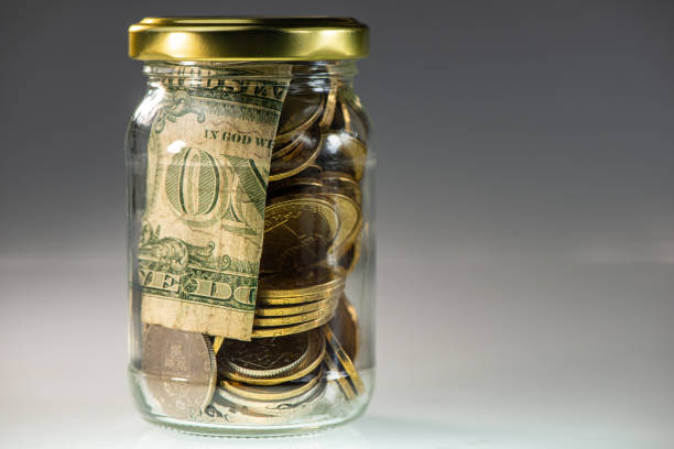 istock Lid closed glass jar with coins and banknotes. 1220111380