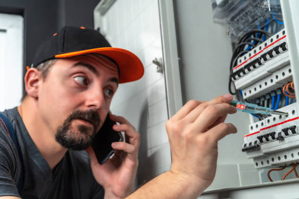 istock Electrician checking fuse box and use smart phone 1220113177