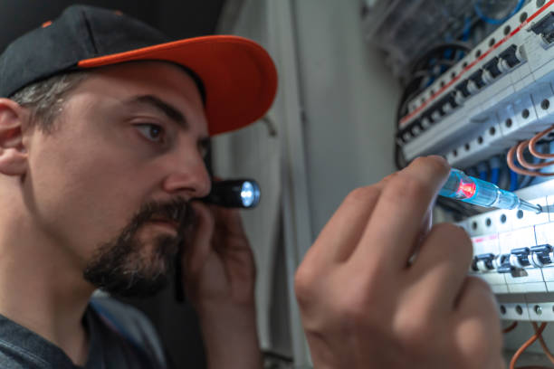 istock Electrician use flashlight to repair fuse box, close-up 1220113367