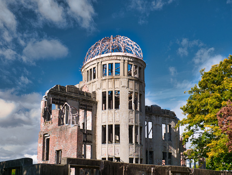 Against a blue sky with light clouds, the Genbaku Dome / Atomic Bomb Dome at the Hiroshima Peace Memorial Park in Hiroshima, Japan - originally the Hiroshima Prefectural Industrial Promotional Hall