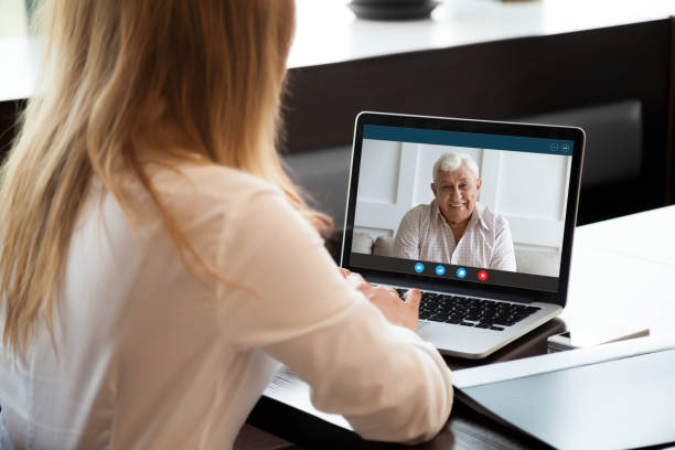 istock Young woman talk on video call with senior father 1220117740