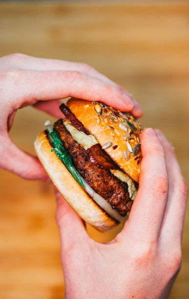istock Hands holding gourmet double Bacon Cheese Burger 1220118595