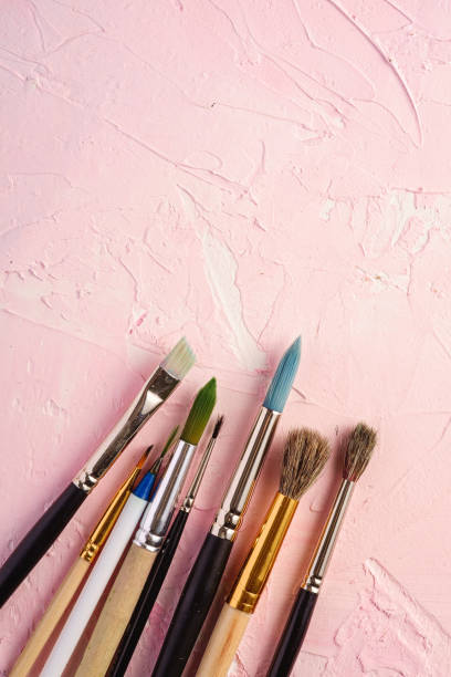 istock Paint brushes, artist tools for drawing on textured pink background, top view, copy space 1220119772