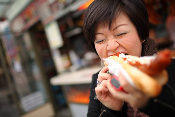 una donna asiatica cinese godendo il suo cibo ceco locale nel centro di praga - burger bun sandwich bread foto e immagini stock