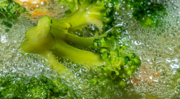 Homemade broccoli and carrot are boiling in a pot stock photo