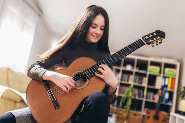 istock Pretty girl practicing some new sound on a guitar at home 1220121856