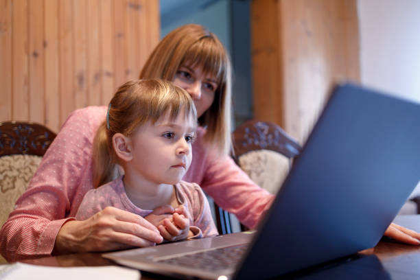 istock Woman with daughter on her lap working from home 1220123011
