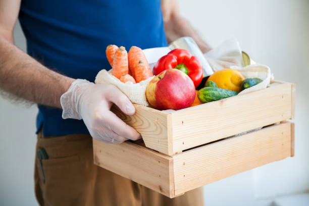 istock Courier in gloves holding a box with food 1220123281
