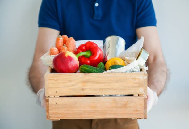 istock Courier in gloves holding a box with food 1220123282