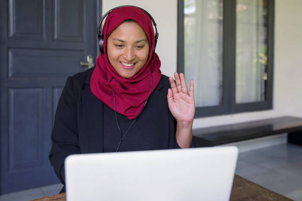 istock Malaysian teacher greeting her online students 1220125258