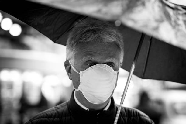 Senior man wearing protective face mask outdoors in the city