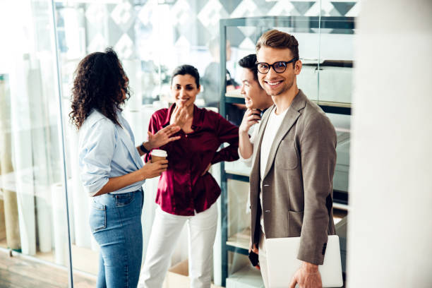 istock Group of joyful young people chatting in office 1220128415
