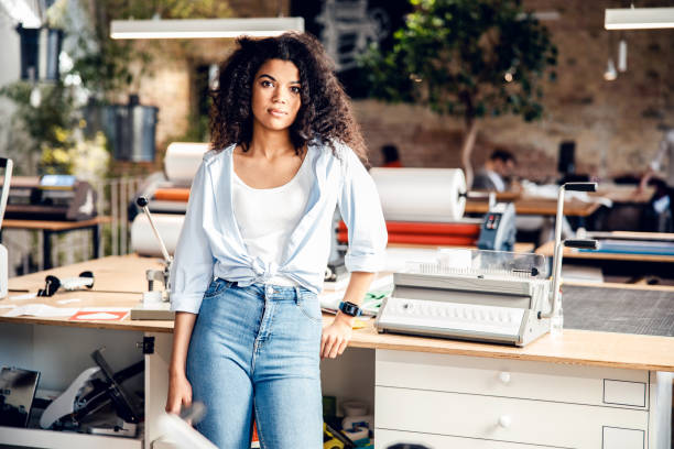 istock Beautiful young woman standing in modern office 1220128464