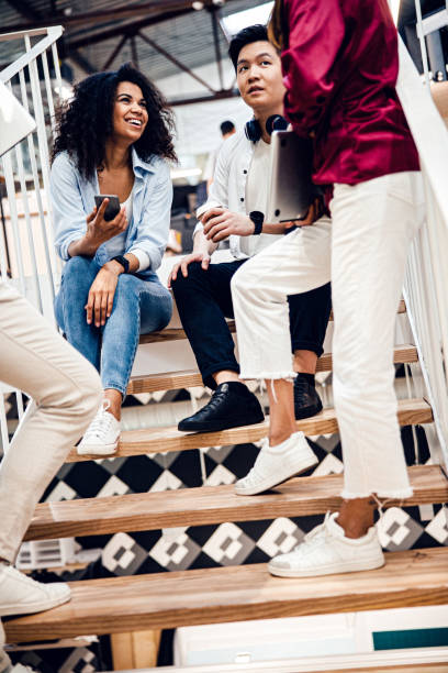 istock Friends chatting and drinking coffee on stairs 1220128482