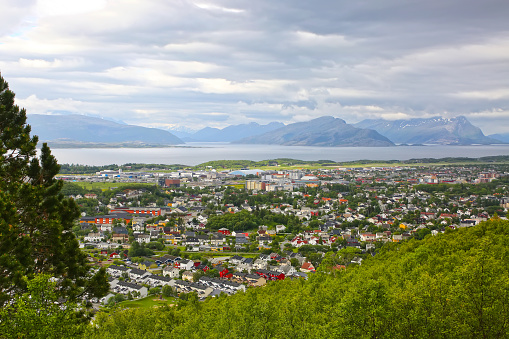 View over the cityscape of Bodo, Norway. Houses in the foreground & the sea & mountains in the background, Scandinavia. Bodø is a municipality in Nordland county, Norway. It is part of the traditional region of Salten.