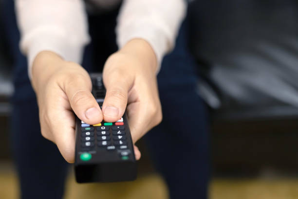 istock Woman is holding a remote control for a digital TV 1220130709