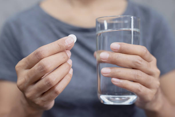 istock A woman is eating a headache medicine 1220131083