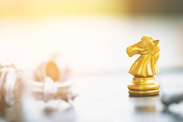 istock golden chess horse moving on a chessboard game fallen victory success. strategy ideas Planning and Decision concept business leader. 1220131890