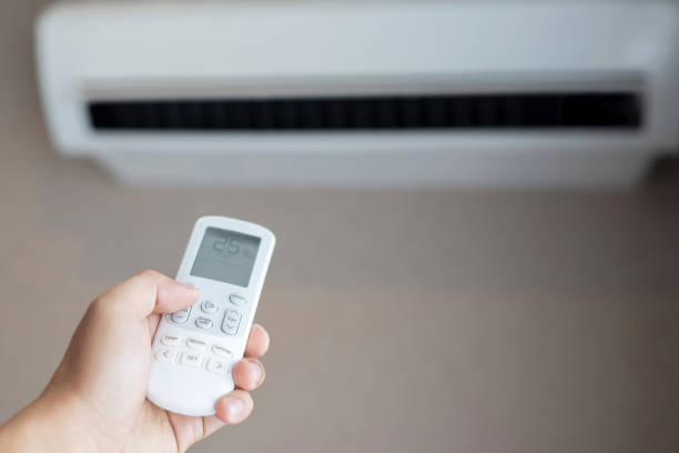 fernbedienung der klimaanlage bei 25 grad celsius, um stromkosten zu sparen - electric fan women wind beautiful stock-fotos und bilder